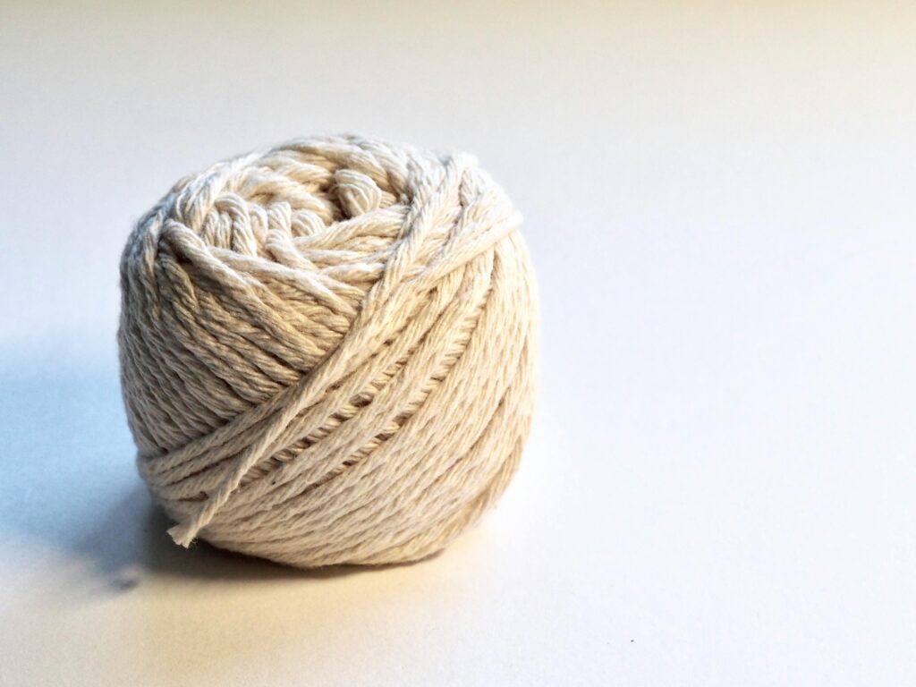 pexels-photo-745761-745761 Detailed close-up of a natural cotton yarn ball on a white background, perfect for textile and crafting themes.